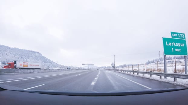 Denver, Colorado, USA-January 26, 2024-The open highway invites a peaceful drive, with snow-clad pines lining I-25 as the journey continues from Denver towards Colorado Springs on a snowy day.