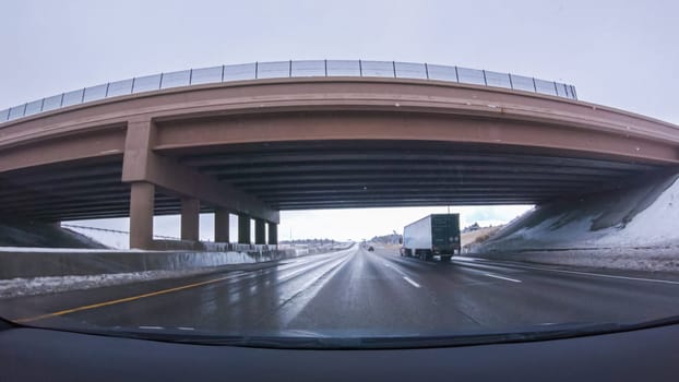 Denver, Colorado, USA-January 26, 2024-The open highway invites a peaceful drive, with snow-clad pines lining I-25 as the journey continues from Denver towards Colorado Springs on a snowy day.