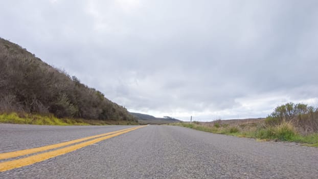 In this serene winter scene, a vehicle carefully makes its way along Los Osos Valley Road and Pecho Valley Road within Montana de Oro State Park.