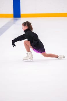 Little girl practicing before her figure skating competition at the indoor ice rink.