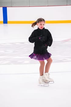 Little girl practicing before her figure skating competition at the indoor ice rink.