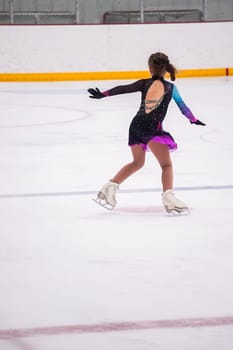 Little girl practicing before her figure skating competition at the indoor ice rink.