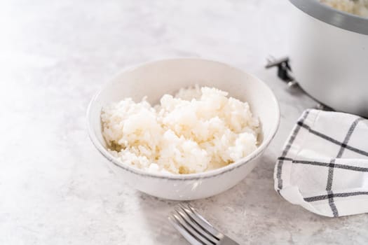 Freshly cooked medium-grain white rice in a white bowl.