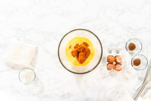 Flat lay. In a cozy kitchen, a large mixing bowl becomes the stage for expertly blending the ingredients, setting the scene for crafting a delightful homemade pumpkin bundt cake from cake mix.