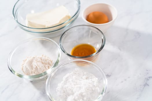 Measured ingredients in glass mixing bowls to make the cream cheese filling.