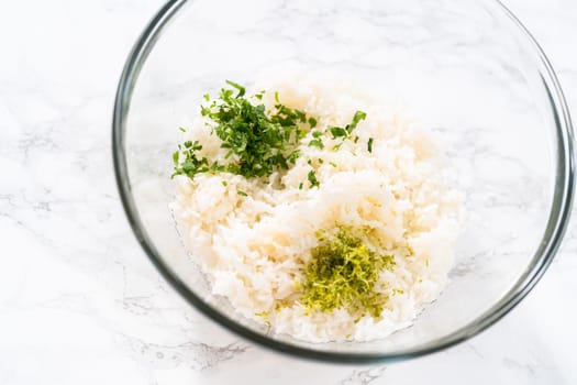 Cilantro Lime Rice. Mixing ingredients in a glass mixing bowl to prepare cilantro lime rice.