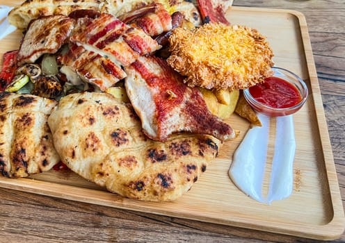 Grilled pork chops and meat bacon steaks and grill with ketchup on a wooden board, Balkan cuisine