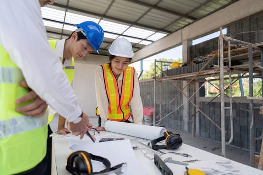 Team of engineer reviewing discussion blueprint at construction site, collaborative planning.