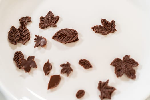 Making chocolate leaves from melted chocolate to decorate the pumpkin bundt cake.