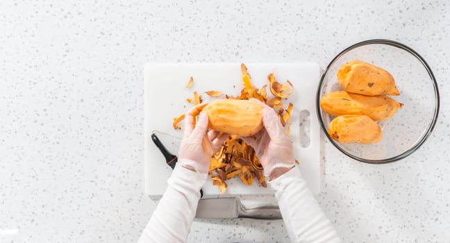 Flat lay. Peeling sweet potatoes with potato peeler to make oven-roasted sweet potatoes