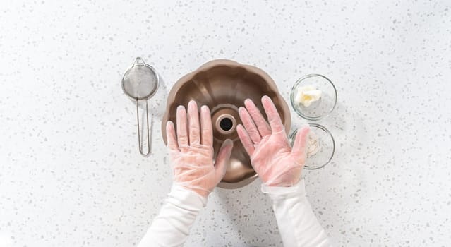 Flat lay. Greasing metal bundt cake pan to bake a simple vanilla bundt cake.