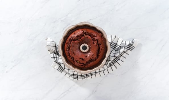 Flat lay. Cooling freshly baked red velvet bundt cake on a kitchen counter.