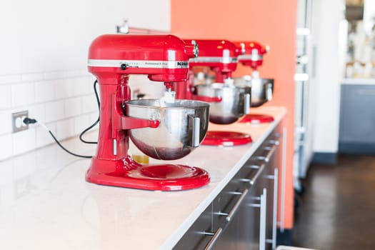 Denver, Colorado, USA-October 30, 2021 - Row of red standing kitchen mixers at the cooking class.