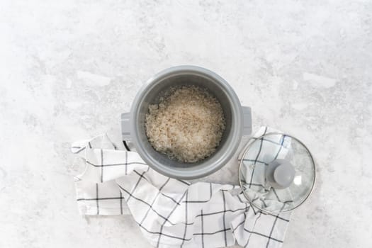 Flat lay. Cooking white rice in a rice cooker.