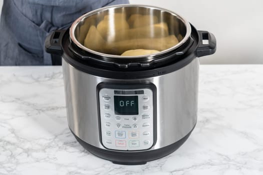 Mashed potatoes. Cooking whole peeled potatoes in a pressure cooker to make mashed potatoes.