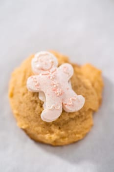 Decorating eggnog cookies with a chocolate gingerbread man.
