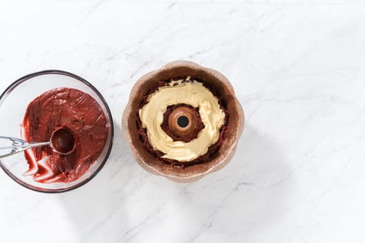 Flat lay. Filling metal bundt cake pan with cake butter to bake red velvet bundt cake with cream cheese glaze