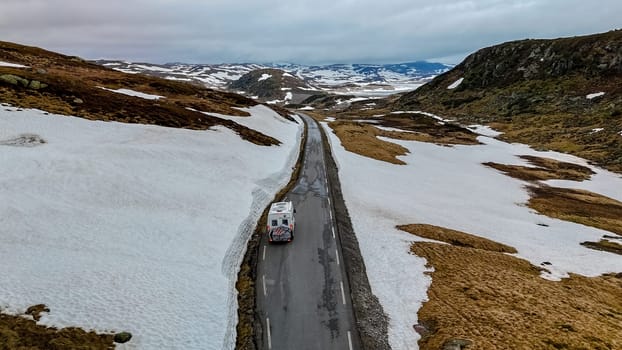 travel camper van, Caravan trailer, or camper RV at the Lyse road covered with snow to Krejag Norway Lysebotn, a road covered with snow in Spring