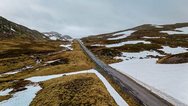 drone view at a Campervan or motorhome travel camper van, Caravan trailer, or camper RV at the Lyse road covered with snow to Krejag Norway Lysebotn, road covered with snow