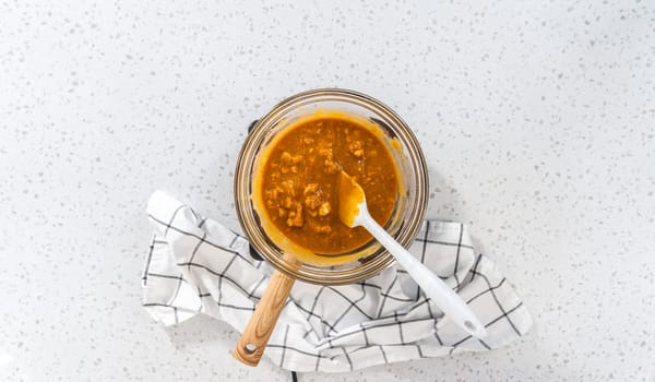 Flat lay. Melting chocolate chips and other ingredients in a glass mixing bowl over boiling water to prepare pumpkin spice fudge.