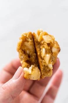 Freshly baked white chocolate macadamia nut on a white plate.