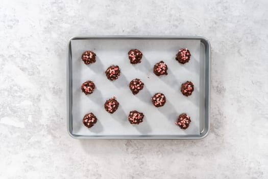 Flat lay. Scooping chocolate cookie dough with dough scoop to bake chocolate cookies with peppermint chips.