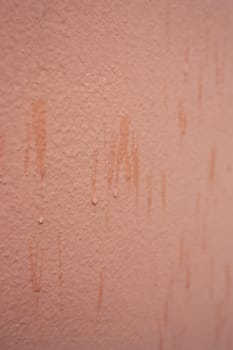 Vertical textured urban background in peach fuzz color. Vintage wall with texture.