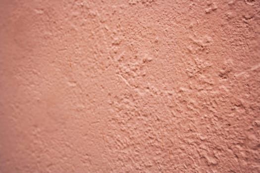 Old textured urban background in peach fuzz color. Vintage wall with texture.