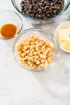 Measured ingredients in glass mixing bowls to make chocolate macadamia fudge.