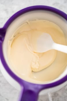 Melting white chocolate chips in a candy melting pot to make chocolate cookies with peppermint chips.