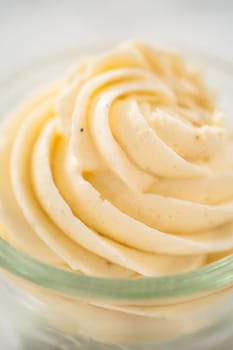 Swirl of eggnog buttercream frosting in a small glass bowl.