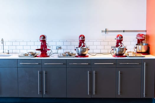 Denver, Colorado, USA-October 30, 2021 - Row of red standing kitchen mixers at the cooking class.