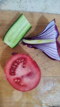 vegetables on the kitchen board, cucumber tomato, onion food salad. High quality photo