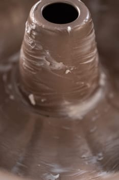 Greasing metal bundt cake pan to red velvet bundt cake with cream cheese glaze.