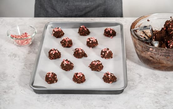 Scooping chocolate cookie dough with dough scoop to bake chocolate cookies with peppermint chips.