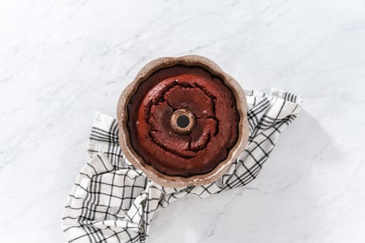 Flat lay. Cooling freshly baked red velvet bundt cake on a kitchen counter.