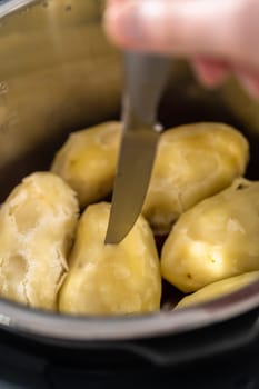 Mashed potatoes. Cooking whole peeled potatoes in a pressure cooker to make mashed potatoes.