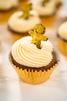 Freshly baked gingerbread cupcakes with eggnog buttercream frosting and topped with a gingerbread man.