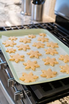 Letting delightful snowflake-shaped sugar cookies cool after baking, preparing them for festive Christmas gifts.