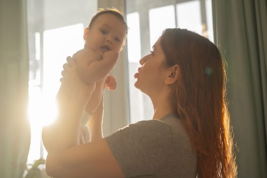 Caucasian woman gently lifts up her newborn son