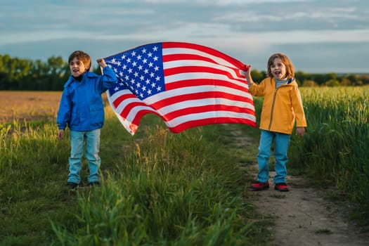 Cute little boys brothers - American patriot kids with national flag on open area countryside road.USA, 4th of July - Independence day, celebration. US, memorial Veterans, election, America, labor