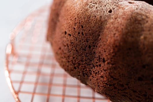 Cooling freshly baked red velvet bundt cake on a kitchen counter.