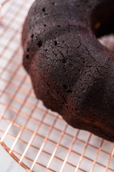 Cooling freshly baked red velvet bundt cake on a kitchen counter.