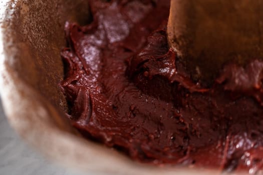 Filling metal bundt cake pan with cake butter to bake red velvet bundt cake with cream cheese glaze