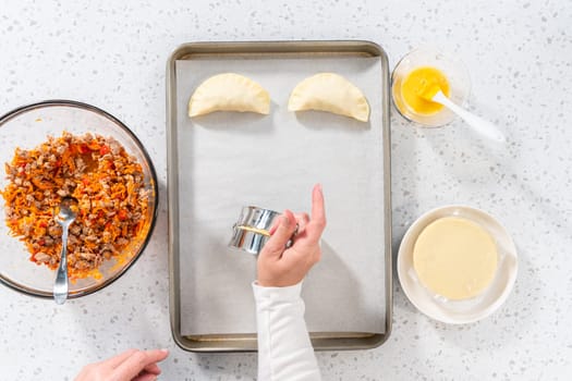 Flat lay. Filling empanada dough with turkey filling to make turkey empanadas.