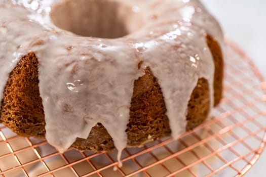 Glazing vanilla bundt cake with a white vanilla glaze.