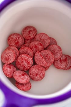 Melting red chocolate chips in a candy melting pot to make chocolate lips and heart shaped chocolates for Valentine's Day.