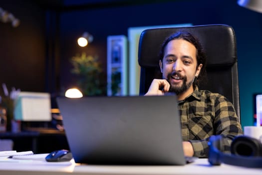 Freelancer working from the comfort of their home, surrounded by a contemporary and neat living room setup, using a laptop to browse the web and communicate, exemplifying the modern online lifestyle.