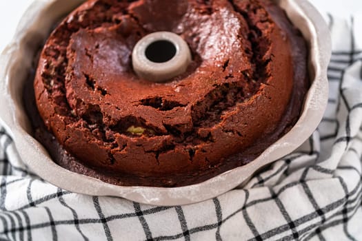 Cooling freshly baked red velvet bundt cake on a kitchen counter.