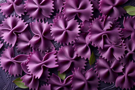 A close-up view of purple farfalle pasta arranged in a visually appealing pattern on a black surface. The pasta is dry and ready to be cooked.